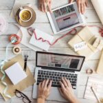 Immagine di un marketer al lavoro su un laptop con grafici e strategie di marketing digitale.