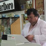 Immagine di un tabaccaio con biglietti Gratta e Vinci e clienti sorridenti nel negozio.