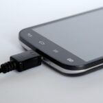 Caricabatterie del telefono con spina inserita in una presa elettrica.